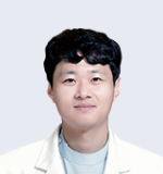 흰 가운 차림으로 미소 짓는 젊은 안과 전문의 사진